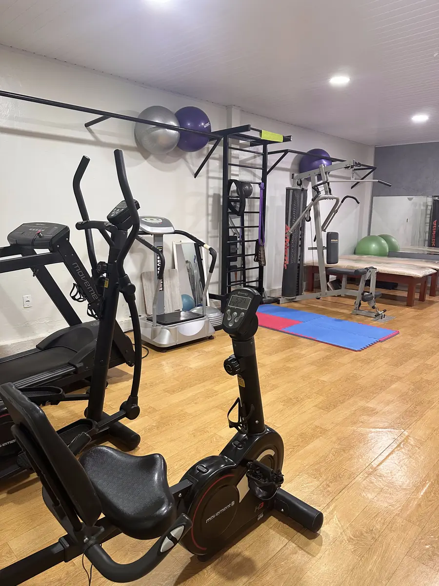 Sala de reabilitação e fortalecimento com esteira, bicicleta e espaldar